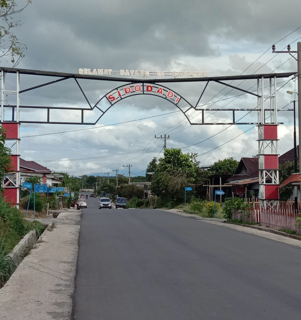 gapura selamat datang ke kampung sidodadi yang di bangun di perbatasan kampung jadi sepakat.